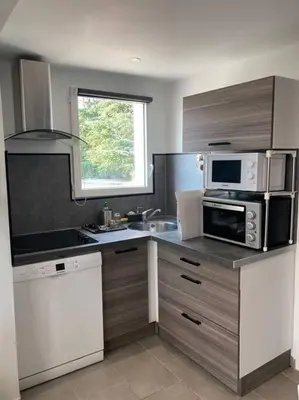 a kitchen with a microwave oven and a sink at Superbe appartement au calme et vue sur la mer in Cagnes-sur-Mer