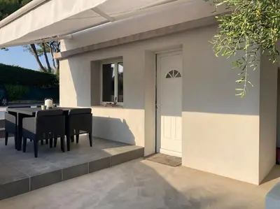 a table and chairs sitting next to a house at Superbe appartement au calme et vue sur la mer in Cagnes-sur-Mer