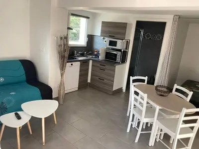 a living room with a table and a kitchen at Superbe appartement au calme et vue sur la mer in Cagnes-sur-Mer