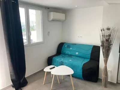 a living room with a blue couch and a table at Superbe appartement au calme et vue sur la mer in Cagnes-sur-Mer