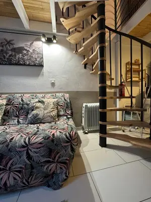 a living room with a couch and a spiral staircase at Duplex spagiari in Nice