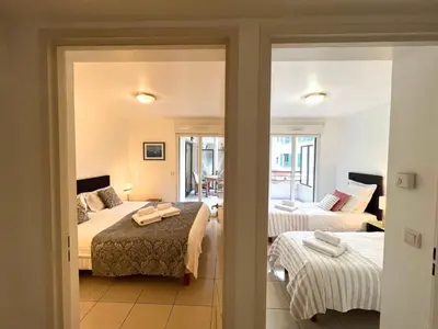 a hotel room with two beds and a living room at Sunlight Properties - Mirage - Central Nice with Parking and Terrace in Nice