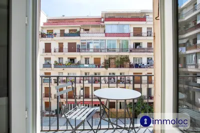 a balcony with a table and chairs and a building at Apartment T2 Air-conditioned district Libération in Nice