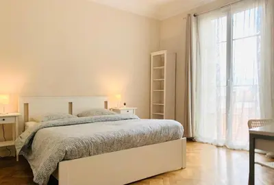a white bedroom with a bed and a large window at Chic & Spacious Getaway in Nice - 10min to Beach in Nice