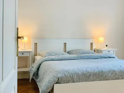 a bedroom with a bed with a blue comforter at Chic & Spacious Getaway in Nice - 10min to Beach in Nice