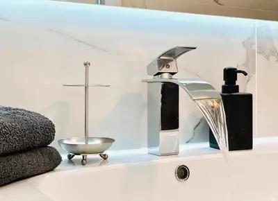 a bathroom sink with a faucet and a soap dispenser at Chic & Spacious Getaway in Nice - 10min to Beach in Nice