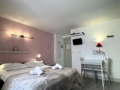 a bedroom with two beds and a table and a desk at ApartHotel Riviera - MALONAT 3 - Grand Studio très calme -Old Town Promenade des Anglais in Nice