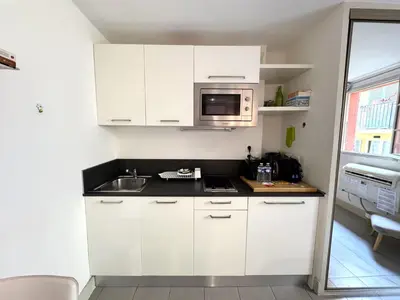 a white kitchen with a sink and a microwave at ApartHotel Riviera - MALONAT 3 - Grand Studio très calme -Old Town Promenade des Anglais in Nice