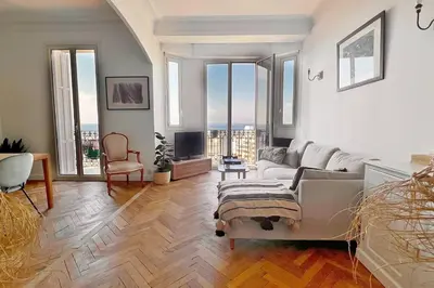a living room with a couch and a tv at Le Palais Riviera in Nice