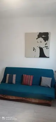 a blue couch in a living room with a painting at Nice Charmant 2 pièces in Nice
