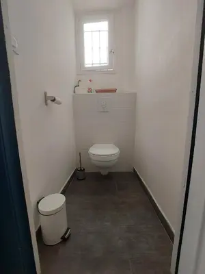 a white bathroom with a toilet and a window at Nice Charmant 2 pièces in Nice