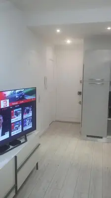 a living room with a television and a white wall at Nice Charmant 2 pièces in Nice