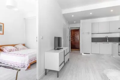 a white bedroom with a bed and a tv at Nice Charmant 2 pièces in Nice