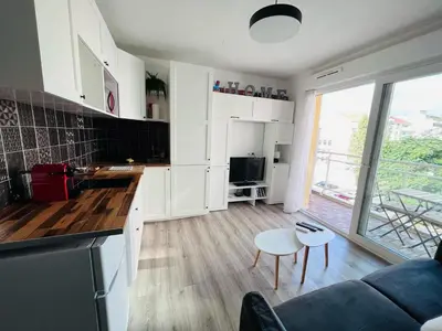 a kitchen and living room with a couch and a table at Studio terrasse et parking privé in Nice