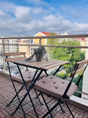 a wooden table and two chairs on a balcony at Studio terrasse et parking privé in Nice