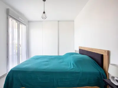 a bedroom with a green bed and a window at Apartment Rive de Cagnes by Interhome in Cagnes-sur-Mer