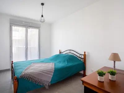 a bedroom with a green bed and a table at Apartment Rive de Cagnes by Interhome in Cagnes-sur-Mer