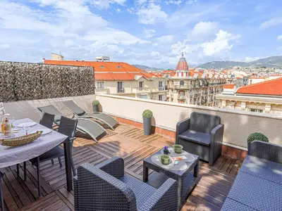 a balcony with tables and chairs on a roof at Apartment Les terrasses de l'Escurial by Interhome in Nice