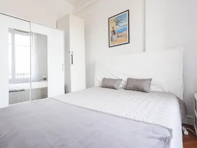 a white bedroom with a white bed and a mirror at Apartment Les terrasses de l'Escurial by Interhome in Nice