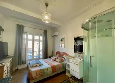 a bedroom with a bed and a glass shower at Les chambres de Cédric ICONIC TRAM GARE Nice Ville pour personnes CALMES in Nice