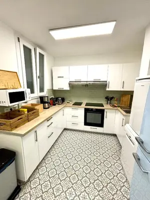 a kitchen with white cabinets and a tile floor at Les chambres de Cédric ICONIC TRAM GARE Nice Ville pour personnes CALMES in Nice