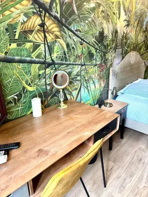 a desk in a room with a wall with plants at Les chambres de Cédric ICONIC TRAM GARE Nice Ville pour personnes CALMES in Nice