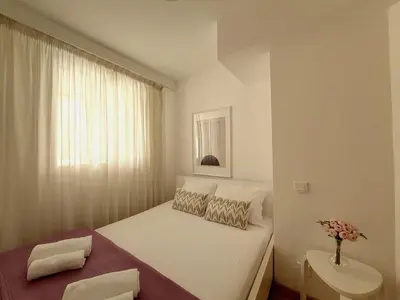 a small bedroom with a bed and a vase of flowers at Nestor&Jeeves - COEUR RIVIERA - City Center - Near Beach in Nice