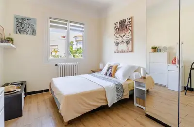 a bedroom with a large bed and two windows at Cosy appartement, Vue Mer panoramique in Nice