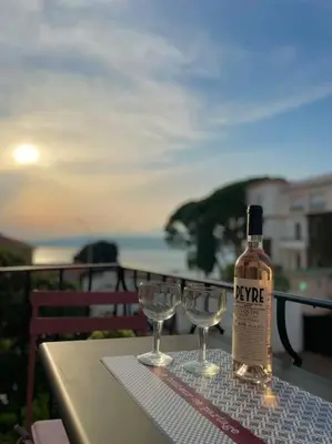 a bottle of wine sitting on a table with two wine glasses at Cosy appartement, Vue Mer panoramique in Nice
