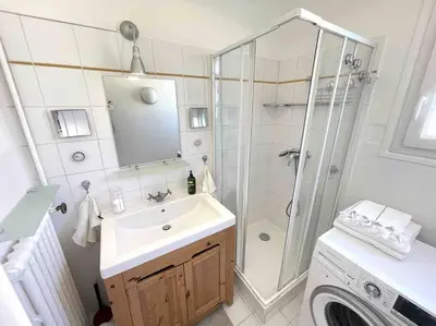 a bathroom with a sink and a shower and a washing machine at Cosy appartement, Vue Mer panoramique in Nice