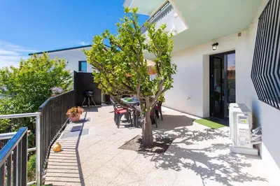 a patio with a tree and a table and chairs at Echapée Belle - Vinayard view - Jacuzzi BBQ - parking in Nice