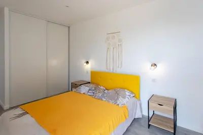 a bedroom with a yellow bed and a table at Echapée Belle - Vinayard view - Jacuzzi BBQ - parking in Nice