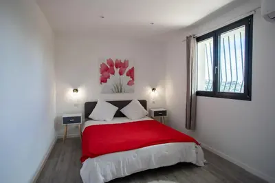 a white bedroom with a red bed with a window at Echapée Belle - Vinayard view - Jacuzzi BBQ - parking in Nice