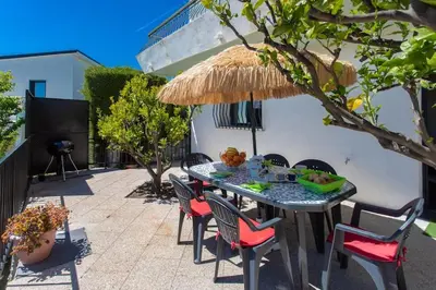 a patio with a table with chairs and a straw umbrella at Echapée Belle - Vinayard view - Jacuzzi BBQ - parking in Nice