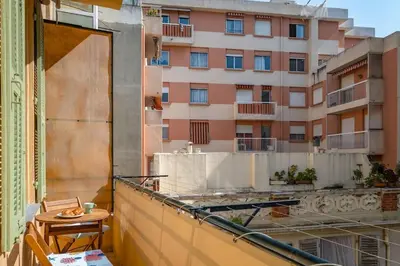 a balcony with a table and a building at La Cachette du Port! -Avec parking au Port de Nice in Nice