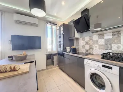 a kitchen with a washing machine and a tv at Nestor&Jeeves - PALAIS HISPANIA - Top floor apartment in Nice