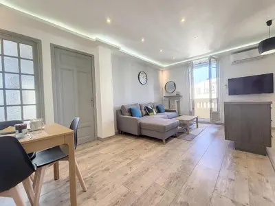a living room with a couch and a table at Nestor&Jeeves - PALAIS HISPANIA - Top floor apartment in Nice