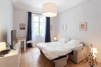 a white bedroom with a bed and a desk at 26 Nice Parc Imperial studio in Nice