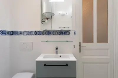 a bathroom with a sink and a mirror and a door at 26 Nice Parc Imperial studio in Nice