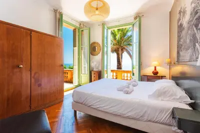 a bedroom with a bed and a large window at Villa Reve d azur vi4353 by Riviera Holiday Homes in Nice