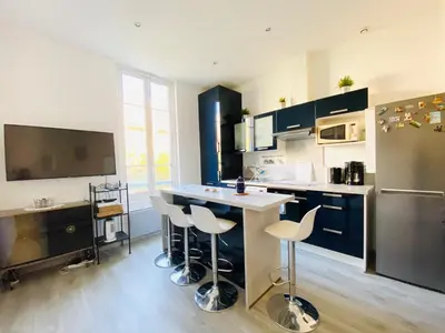 a large kitchen with a counter and stools in it at 2 Pièces Neuf WIFI Quartier Borriglione in Nice