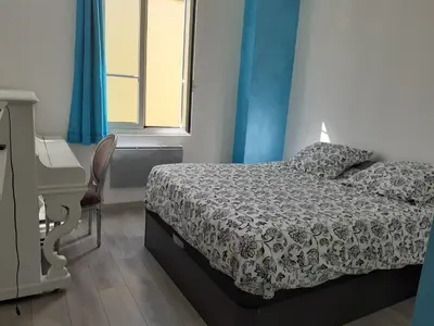 a bedroom with a bed and a desk and a window at 2 Pièces Neuf WIFI Quartier Borriglione in Nice