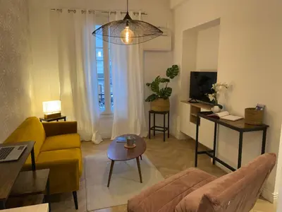 a living room with a yellow couch and a table at Magnifique appartement moderne - Clim & Wifi in Nice