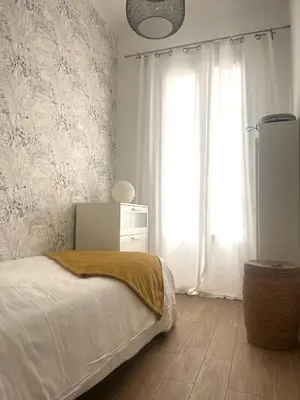 a bedroom with a bed and a large window at Magnifique appartement moderne - Clim & Wifi in Nice