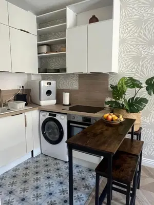 a kitchen with a table and a dishwasher at Magnifique appartement moderne - Clim & Wifi in Nice