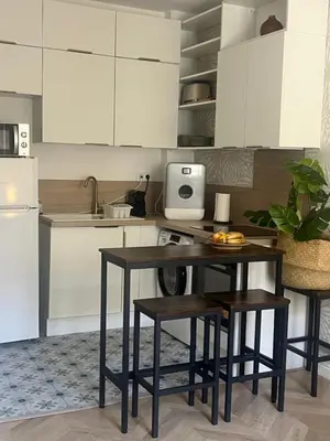 a kitchen with a table and stools in a kitchen at Magnifique appartement moderne - Clim & Wifi in Nice