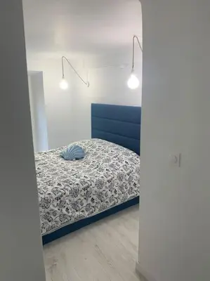 a bedroom with a bed with a blue head board at Nouveau - Nice Mamac - centre in Nice
