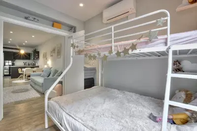 a bedroom with two bunk beds and a living room at La Maison Hélène & Antoine Nice Le Port in Nice
