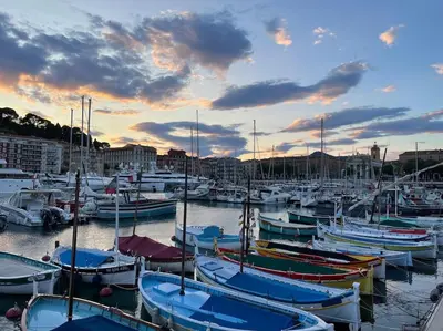 a group of boats docked in a harbor at sunset at La Maison Hélène & Antoine Nice Le Port in Nice