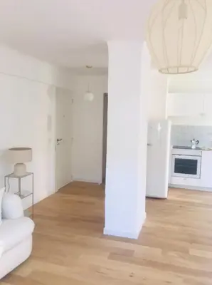 a white living room with a white couch and a kitchen at Magnifique appartement Bas Gairaut aperçu mer in Nice
